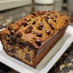 Close-up of a slice of chocolate chip banana bread with chocolate chips visible.