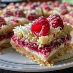 Close-up view of juicy Raspberry Coconut Bars on a plate.