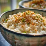 Close-up view of creamy coconut rice pudding topped with chopped nuts.