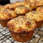 Close-up of golden-brown gluten-free savory muffins displaying a light cheese topping.