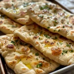 Close-up of a golden-brown no-yeast flatbread on a stovetop.