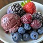 Close-up view of Frozen Berry Yogurt Bites featuring blueberries and strawberries coated in yogurt.