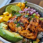 Close-up view of a BBQ salmon bowl featuring mango avocado salsa.