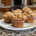 Close-up view of freshly baked apple cinnamon muffins with a golden-brown crust.