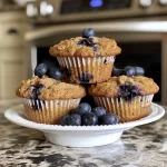 Close-up view of delicious blueberry muffins with oats, showcasing a golden-brown top.