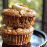 Close-up side view of Healthy Peanut Butter Banana Muffins on a wooden surface.