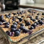 Close-up view of a baked dish featuring blueberries and cottage cheese.