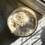 Close-up view of a creamy cottage cheese smoothie with frozen peaches.