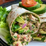 Close-up of a colorful Avocado Ranch Tuna Wrap, showcasing layers of tuna, avocado, and veggies.