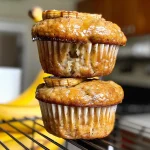 Close-up view of golden brown banana protein muffins on a plate.