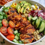 Close-up view of a BBQ Chicken Power Bowl featuring grilled chicken, quinoa, and fresh vegetables.