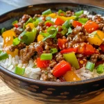 A close-up view of a Beef and Pepper Rice Bowl featuring ground beef and colorful bell peppers over white rice.