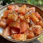 Close-up of crispy pickled watermelon rind in a glass jar.