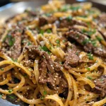 Close-up of Garlic Butter Beef Noodles topped with minced parsley.