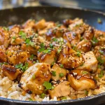 Close-up of a flavorful Garlic Honey Chicken Rice Skillet with golden chicken pieces.