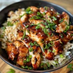 Close-up of sizzling Honey BBQ Chicken served over rice in a pan.