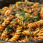 Close-up view of a creamy beef and garlic parmesan spinach pasta dish in a bowl.