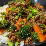 Close-up view of savory ground beef teriyaki with broccoli and carrots in a bowl.