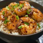 A colorful Spicy Honey Garlic Shrimp Bowl featuring shrimp, rice, and green onions.