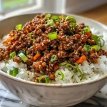 Close-up view of a Spicy Korean Ground Beef Bowl with garnishes.
