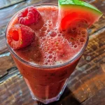 Close-up view of a refreshing watermelon smoothie in a glass, garnished with mint leaves.