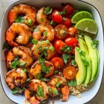 ['Close-up view of BBQ shrimp meal prep bowl with limey avocado salsa.', 'Colorful meal prep bowl featuring juicy shrimp, cherry tomatoes, and avocado.', 'Side view of a vibrant BBQ shrimp meal with rice and garnishes in a bowl.', 'Detailed shot of shrimp, avocado, and lime ingredients in a meal prep setting.']
