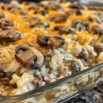 ['Close-up view of a creamy beef and mushroom rice bake topped with melted cheese.', 'Side angle of a baked dish featuring ground beef, mushrooms, and rice in a creamy sauce.', 'Juicy and delicious creamy beef and mushroom rice bake served in a baking dish.', 'A hearty serving of creamy beef rice casserole with mushrooms and cheese on top.']