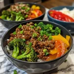 ['Close-up view of a delicious teriyaki beef meal prep bowl with colorful vegetables.', 'Side view of a meal prep bowl featuring ground beef and vibrant broccoli and peppers.', 'Juicy teriyaki beef mixed with vegetables in a meal prep container, garnished with green onions.', 'Tasty easy teriyaki beef bowl filled with colorful ingredients served in a bowl.']
