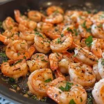 ['Close-up of a Garlic Shrimp Skillet with golden-brown shrimp and garnished with parsley.', 'Juicy garlic shrimp sizzling in a skillet, with visible garlic and a sprinkle of red pepper flakes.', 'A side view of a pan-seared garlic shrimp dish, featuring vibrant colors and a glossy sauce.', 'Deliciously cooked shrimp in a buttery garlic sauce, highlighted with lemon zest and herbs.']