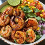 ['Close-up of a grilled shrimp bowl with avocado corn salsa.', 'Juicy grilled shrimp served over quinoa with vibrant avocado and corn toppings.', 'Side view of a colorful shrimp bowl featuring grilled shrimp, diced avocado, and corn.', 'Detailed view of a healthy grilled shrimp bowl, highlighting fresh ingredients.']