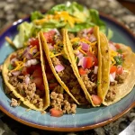 ['Close-up view of a juicy ground turkey taco filled with fresh ingredients.', 'Side angle of a colorful ground turkey taco on a plate, showcasing its toppings.', 'Detailed shot of a homemade ground turkey taco with vibrant toppings and garnishes.', 'A close-up image of ground turkey tacos ready to be enjoyed, featuring melted cheese and fresh veggies.']