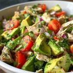 ['A close-up side view of a vibrant avocado chicken salad in a bowl, showcasing the fresh ingredients.', 'A colorful, healthy avocado chicken salad with diced chicken, avocados, and vegetables, captured from the side.', 'Side view of a delicious avocado chicken salad featuring diced ingredients, presented attractively in a bowl.', 'A visually appealing close-up of a chicken salad, highlighting ripe avocados and fresh veggies.']