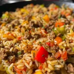 ['Juicy rice and beef served in a bowl, showcasing vibrant bell peppers and spices.', 'Close-up of a hearty rice and beef dish, topped with diced vegetables and herbs.', 'A side view of savory rice and beef, highlighting the colorful ingredients and textures.', 'Deliciously plated rice and beef mix with tomatoes and bell peppers, ready to eat.']