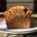 ['Close-up side view of a loaf of Cinnamon Maple Butternut Squash Bread on a wooden board.', 'Freshly baked Cinnamon Maple Butternut Squash Bread with a golden-brown crust and a slice partially cut.', 'Moist and fluffy Cinnamon Maple Butternut Squash Bread displayed on a rustic table.', 'Delicious Cinnamon Maple Butternut Squash Bread with a glossy maple glaze and sprinkled cinnamon.']