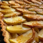 ['Close-up shot of a sliced pear tart with caramelized edges and almond topping.', 'Side view of an easy pear tart showcasing thinly sliced pears and a golden crust.', 'Juicy pear tart with a crispy almond flour base, garnished with sliced almonds.', 'Deliciously presented pear tart highlighting the layers of pear slices and melted butter.']