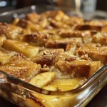 ['Close-up view of Low Calorie Bread Pudding with a golden-brown crust.', 'Side profile of a luscious Low Calorie Bread Pudding topped with pecans and apple chunks.', 'Slice of Low Calorie Bread Pudding showing moist texture and rich color.', 'Juicy Low Calorie Bread Pudding displayed on a plate, garnished with cinnamon.']