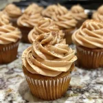 ['Close-up side view of moist pumpkin cupcakes topped with brown butter frosting.', 'Beautifully decorated pumpkin cupcakes with creamy brown butter frosting.', 'Side view of delicious pumpkin cupcakes showcasing rich brown butter frosting.', 'Close-up of scrumptious pumpkin cupcakes adorned with golden brown butter icing.']