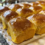 ['Close-up of golden-brown pumpkin dinner rolls with a soft texture.', 'Side view of fluffy pumpkin dinner rolls, showcasing a warm, inviting color.', 'Juicy pumpkin dinner rolls arranged on a rustic wooden surface.', 'Freshly baked pumpkin dinner rolls with a shiny glaze on top.']