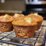 ['Close-up view of golden-brown spiced pear muffins with a soft texture.', 'Side view of freshly baked spiced pear muffins showcasing a moist interior.', 'Juicy spiced pear muffins displayed on a rustic wooden table.', 'Deliciously topped spiced pear muffins ready to be served.']