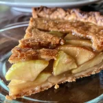 ['Close-up of a beautifully baked Almond Flour Apple Pie showcasing its flaky crust and apple filling.', 'Side view of a golden-brown almond flour apple pie with visible apple slices and a shiny crust.', 'A delicious Almond Flour Apple Pie presented on a wooden table, highlighting its juicy apple filling and crumbly crust.', 'An inviting slice of almond flour apple pie with a rich golden crust and steam rising from freshly baked apples.']