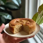 ['Close-up side view of a moist Apple Cider Donut Protein Cake topped with a light glaze.', 'Detailed view of a slice of Apple Cider Donut Protein Cake showcasing its soft texture and spices.', 'Side shot of a deliciously baked Apple Cider Donut Protein Cake with visible cinnamon and nutmeg.', 'A mouth-watering slice of Apple Cider Donut Protein Cake highlighting its protein-rich ingredients.']