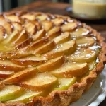 ['Close-up of a golden-brown apple tart drizzled with a shiny cider glaze.', 'Side view of a freshly baked apple tart showcasing sliced Granny Smith apples.', 'Juicy apple tart with a glossy cider glaze highlighting its flaky crust.', 'Detailed view of a delicious apple tart featuring caramelized apple slices.']