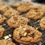 ['Close-up of brown butter harvest cookies with pecans and cranberries.', 'Side view of delicious brown butter cookies topped with seeds and oats.', 'Detailed shot of baked brown butter cookies with a golden-brown crust.', 'Juicy brown butter cookies featuring a mix of nuts and dried fruit.']