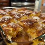 ['Close-up view of a slice of Copycat Krispy Kreme Donut Bread Pudding.', 'Side view of a golden-brown donut bread pudding topped with powdered sugar.', 'Delicious bread pudding made from Krispy Kreme donuts, showcasing its fluffy texture.', 'A tempting serving of donut bread pudding, highlighting its rich and creamy layers.']