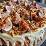 ['Close-up view of a delicious Fig Walnut Cake showcasing its moist texture and rich toppings.', 'Side view of a Fig Walnut Cake, highlighting its layers and decorative walnut pieces.', 'Detailed shot of a Fig Walnut Cake with glistening figs and walnut praline topping.', 'Close-up of a Fig Walnut Cake revealing its creamy filling and nutty crust.']