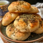 ['Close-up of fluffy zaatar manakish flatbread, highlighting its crispy edges and aromatic herb topping.', 'Side view of delicious zaatar manakish, showcasing a golden crust and sprinkled zaatar spice blend.', 'Juicy zaatar manakish flatbread with a soft, fluffy texture and olive oil drizzle, presented on a wooden board.', 'Detailed view of zaatar manakish flatbread, featuring a rich, herby topping and inviting appearance.']