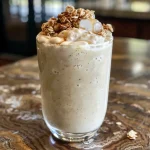 ['Close-up view of a creamy maple apple crisp smoothie with visible apple pieces and oats.', 'Side shot of a delicious smoothie featuring honeycrisp apples and a sprinkle of cinnamon.', 'Thick smoothie in a glass, showcasing its rich color and texture with oats and banana.', 'Refreshing smoothie with a frosty appearance, garnished with apple slices against a simple backdrop.']