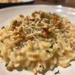 ['Close-up view of creamy Risotto alla cannella with a sprinkle of cinnamon and herbs.', 'Side angle shot of rich Risotto alla cannella featuring grains and garnishes.', 'Detailed image of a bowl of Risotto alla cannella, showcasing rice and aromatic ingredients.', 'Juicy Risotto alla cannella presented on a plate, highlighting its texture and color.']