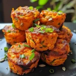 ['Close-up view of a savory sweet potato muffin, showcasing its golden-brown top and moist interior.', 'Side view of a freshly baked savory sweet potato muffin, highlighting its texture and ingredients.', 'Detailed image of a savory sweet potato muffin, focusing on the sprinkled parmesan cheese and colorful toppings.', 'Side shot of a deliciously baked savory sweet potato muffin, revealing the fluffy texture and vibrant spring onions.']