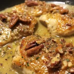 ['Juicy Pecan Chicken breast with a golden crust and chopped pecans on top.', 'Close-up of crispy Pecan Chicken garnished with toasted pecans and a creamy sauce.', 'Delicious Pecan Chicken dish highlighting the crunchy topping and succulent meat.', 'Side view of tender Pecan Chicken served with a rich cream sauce and pecans.']